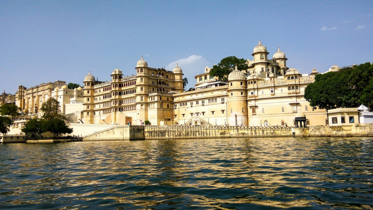 The City Palace lit at dusk on the banks of Lake Pichola in Udaipur